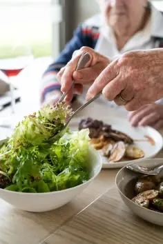 Salade servie à table à une personne âgée